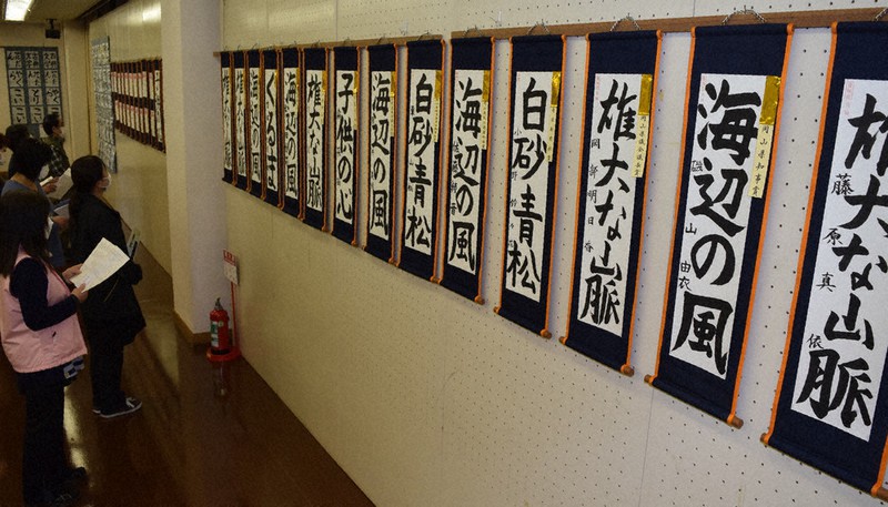 日東書道連盟全国展の会場準備の仕上げをする関係者=倉敷市玉島阿賀崎1の市玉島文化センターで、小林一彦撮影
