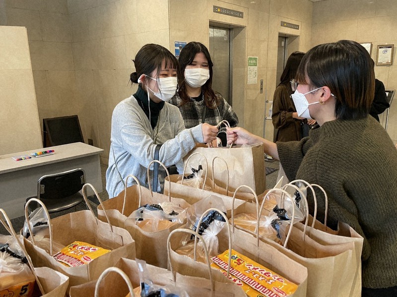 袋詰めした食料を手渡す大学生ら=神戸市中央区で2021年10月24日(実行委提供)