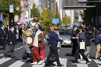 A Japanese "chindon-ya" marching band spreads fliers advertising for local businesses in Tokyo, on Nov. 25, 2021. (AP Photo/Hiro Komae)