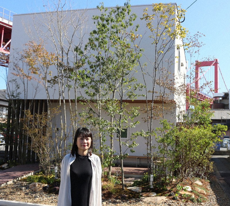 庭園前に立つ重永さん。会社のホームページ上でも毎日、庭園やモデルハウス内部からメッセージを発信し続けている