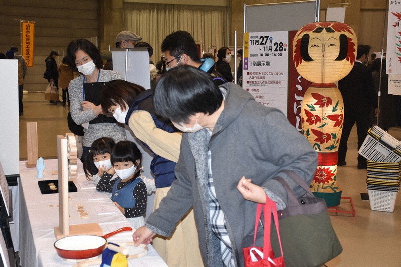 学生のアイデアを取り入れた工芸品に興味津々の来場者=山形市平久保の山形ビッグウイングで2021年11月28日、小寺泰介撮影