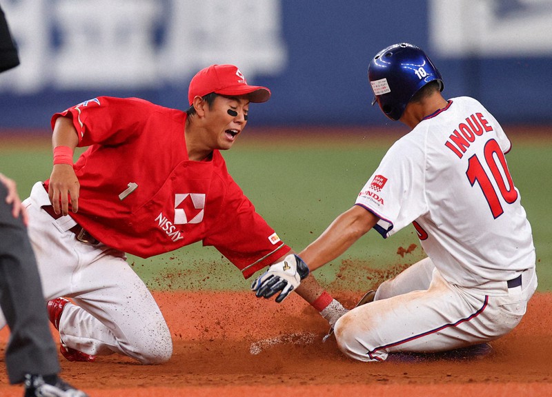 2021年夏の日本選手権の遊撃の守備で、相手走者にタッチする伊藤ヴィットル選手(左)=京セラドーム大阪で2021年7月10日、猪飼健史撮影
