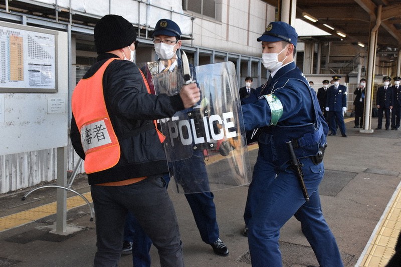 不審者を制圧する警察官=津市羽所町のJR津駅で2021年11月29日、寺原多惠子撮影