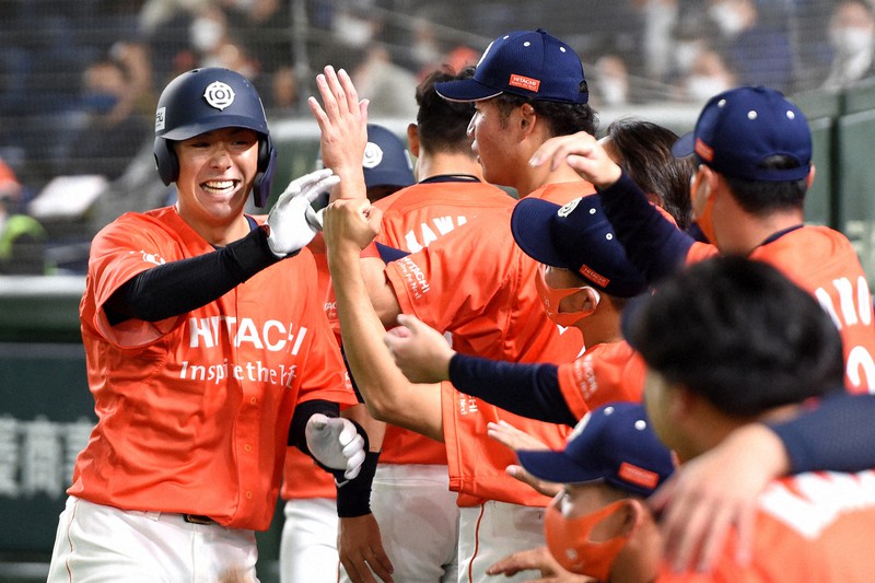 【日立市(日立製作所)-浜松市(ヤマハ)】五回表日立市2死三塁、右越え本塁打を放ち祝福される豊田(左)=東京ドームで2021年11月30日、前田梨里子撮影