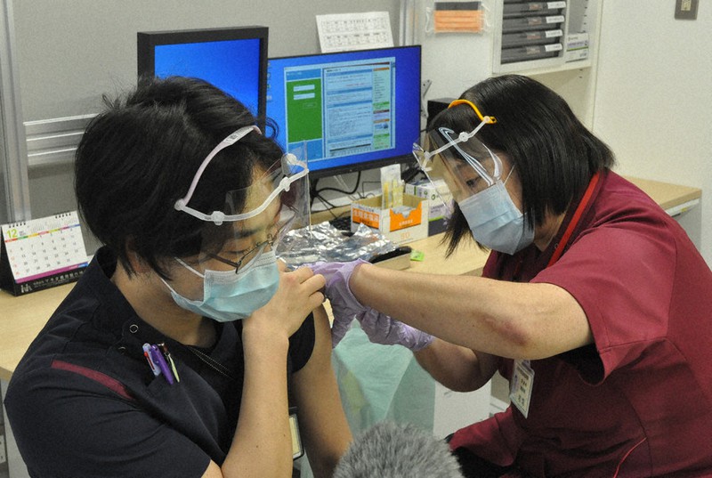 3回目のワクチン接種を受ける医療従事者(左)=宮崎市郡医師会病院