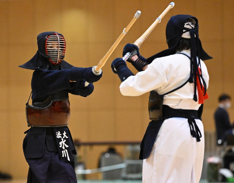 女子の決勝戦で、鹿屋体育大の妹尾を攻める、優勝した法大の水川（左）＝墨田区総合体育館で2021年12月4日、手塚耕一郎撮影