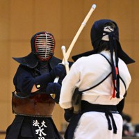 女子の決勝戦で、鹿屋体育大の妹尾を攻める、優勝した法大の水川（左）＝墨田区総合体育館で2021年12月4日、手塚耕一郎撮影