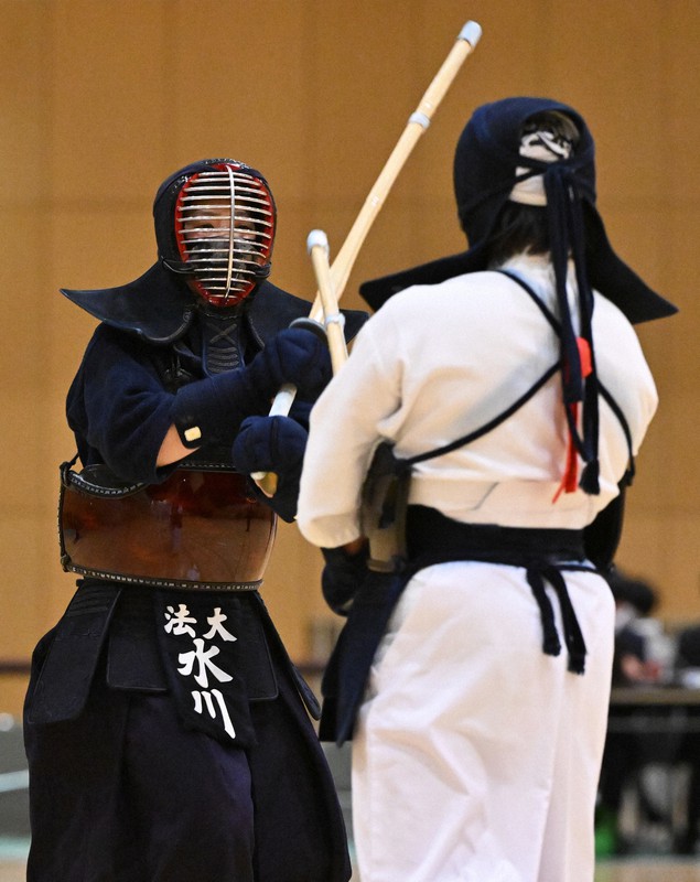 女子の決勝戦で、鹿屋体育大の妹尾を攻める、優勝した法大の水川（左）＝墨田区総合体育館で2021年12月4日、手塚耕一郎撮影