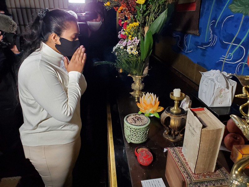 納められたウィシュマさんの遺灰や辞書の前で手を合わせる妹のポールニマさん=愛知県愛西市の明通寺で2021年12月5日午後1時58分、和田浩明撮影