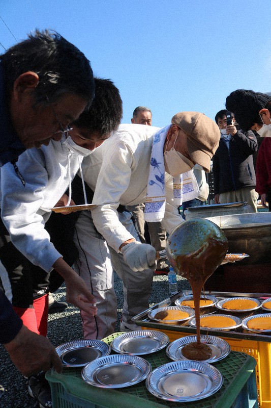 アドバイスを受けながらサトウキビから黒糖を作る参加者