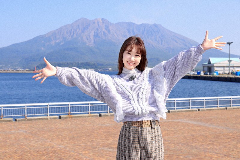 鹿児島の桜島を前にポーズを取る柏木由紀さんⒸ#きゅん旅キャラバン