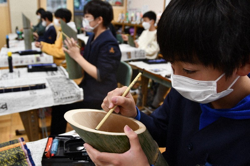 阪神大震災の犠牲者に思いをはせ、文字を書き入れる児童たち=舞鶴市立三笠小で、塩田敏夫撮影