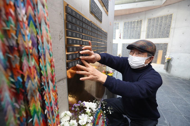 母と姉の銘板を取り付ける増田潤さん=神戸市中央区で2021年12月11日午後2時24分(代表撮影)