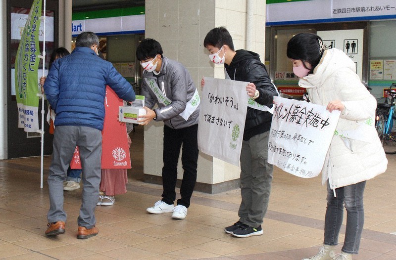 寄せられた善意に頭を下げてお礼をする学生ら=三重県四日市市の近鉄四日市駅北口で2021年12月12日、松本宣良撮影