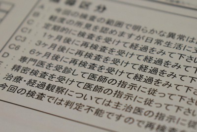 企業が実施する健康診断の結果報告書には、「再検査」や「精密検査」など診断結果に応じた指導内容が書かれている＝東京都内で2021年12月9日午前10時28分、遠山和宏撮影