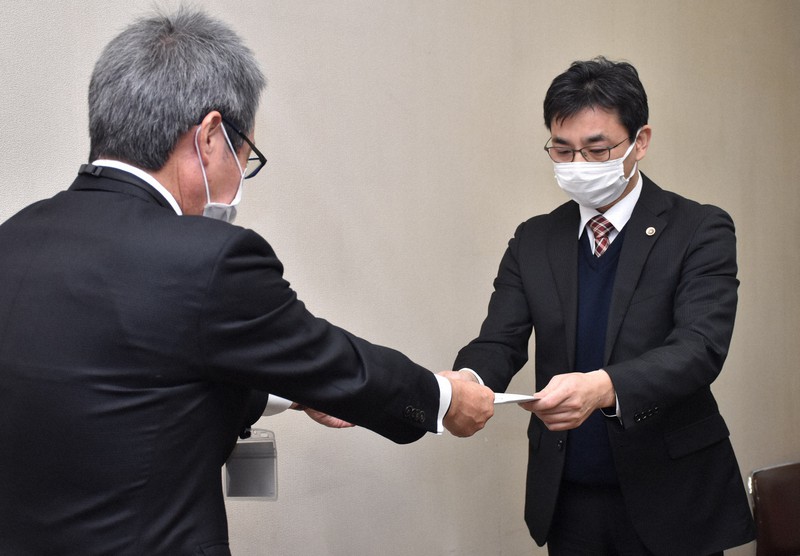 検証委員会の立花隆介委員長(右)から西田耕太郎教育長に意見書が手渡された=姫路市役所で2021年12月24日午後0時45分、後藤奈緒撮影