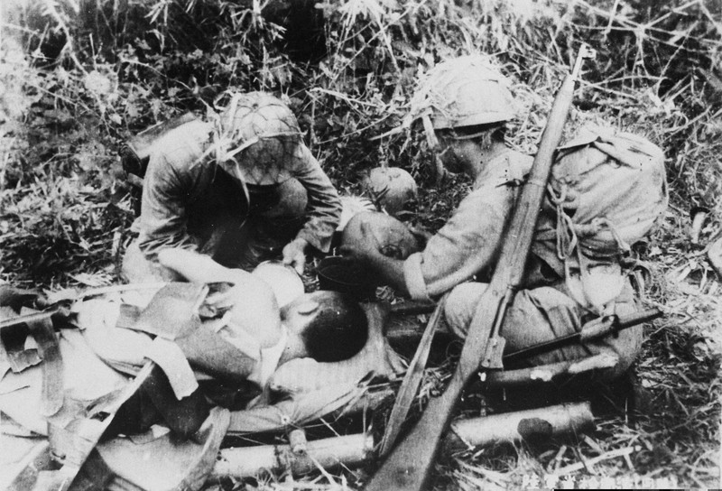 フィリピン・レイテ島で負傷兵に水を与える衛生兵。第二次大戦の日本の敗戦は「情報戦」の敗北でもあった=1944年