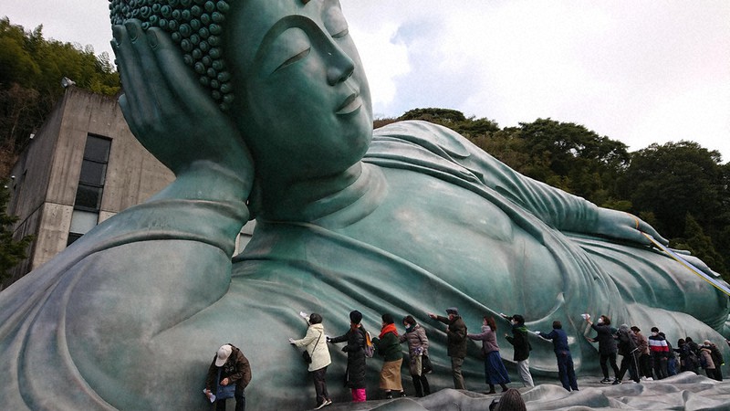 涅槃像を布で拭く参拝客たち
