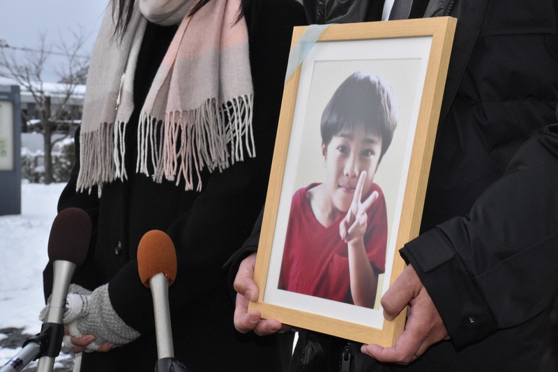 事故で死亡した豊田瑛大さんの遺影を持って取材に応じる両親=福島市の福島地裁前で2021年12月27日午後3時11分、肥沼直寛撮影