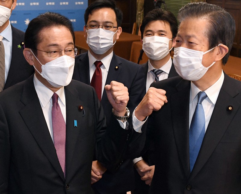 2021年度補正予算が成立後、公明党の山口那津男代表(右)とグータッチをする岸田文雄首相(左)=国会内で2021年12月20日、竹内幹撮影