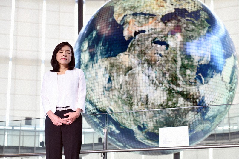 有機ELパネルで表現された地球模型「ジオ・コスモス」の前で記念撮影に応じる日本科学未来館の浅川智恵子館長=東京都江東区で8月、北山夏帆撮影