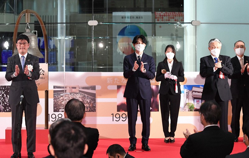 東京証券取引所の大納会で手締めする俳優の吉沢亮さん(中央)ら=東京都中央区で2021年12月30日午後3時16分、前田梨里子撮影