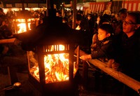 ゆく年とくる年に思いをはせながら灯籠（とうろう）に手を伸ばす＝京都市東山区の八坂神社で2013年12月31日、森園道子撮影
