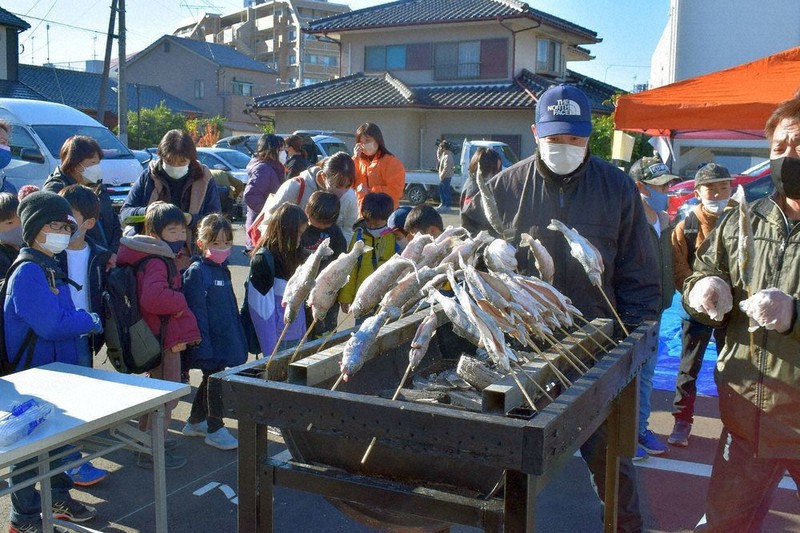 炭火で焼かれるヤマメを見守る子どもたち