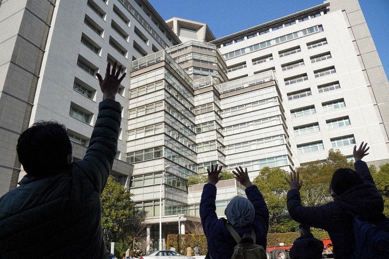 東京出入国在留管理局前で収容者に向かって呼び掛ける支援者たち=2021年12月21日、井田純撮影
