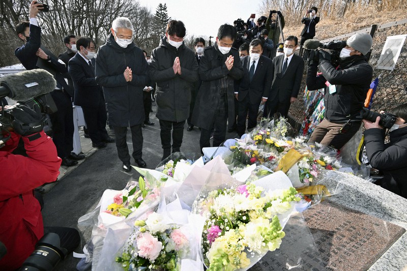 スキーバス転落事故から6年となり、現場近くの慰霊碑の前で手を合わせる遺族の(中央右から)田原義則さん、池田彰さん、大谷慶彦さん=長野県軽井沢町で2022年1月15日午後2時15分、西夏生撮影