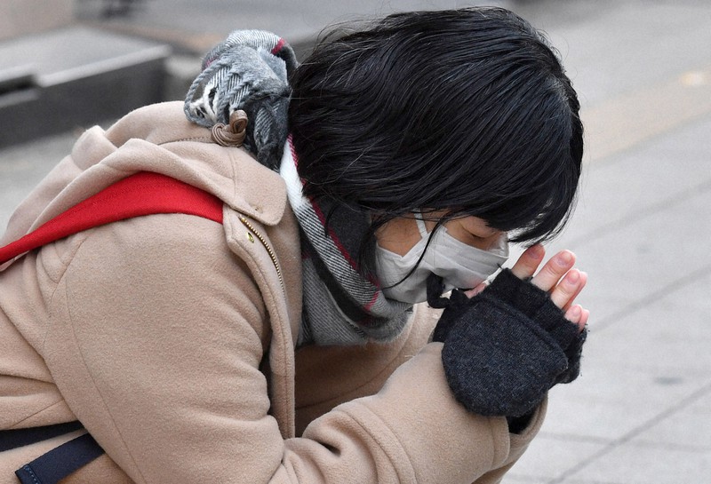 放火事件から1カ月。現場となった雑居ビル前では、手を合わせる人の姿も=大阪市北区で2022年1月17日午前9時1分、木葉健二撮影