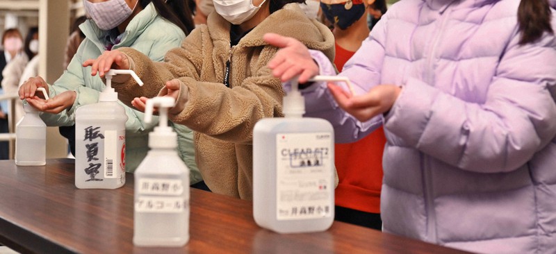 わずか10日前には始業式を実施でき、児童たちが校内で手を消毒する姿も見られたが…=大阪市内で2022年1月11日、山崎一輝撮影