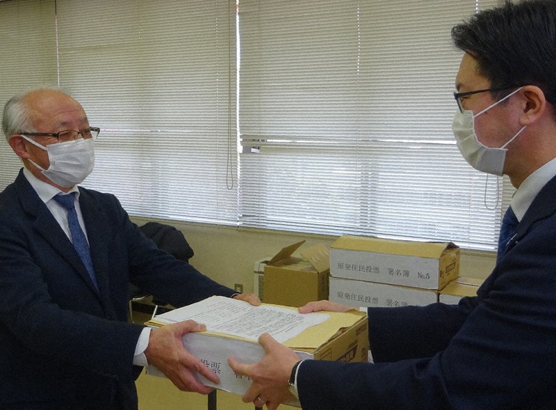伊木隆司市長(右)に条例制定請求書などを手渡す河合康明・共同代表=鳥取県米子市役所で、柴崎達矢撮影