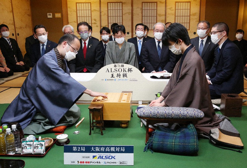 第71期ALSOK杯王将戦七番勝負第2局で初手を指す渡辺明王将(左)。右は挑戦者の藤井聡太竜王=大阪府高槻市の山水館で2022年1月22日午前9時1分、大西達也撮影