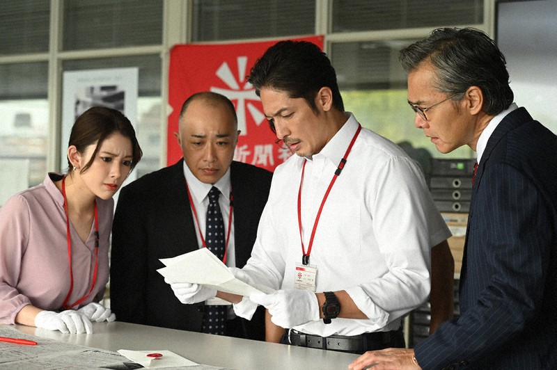 新聞社に届いた手紙に目を通す一本木透(玉木宏、右から2人目)、編集担当取締役の吉村隆一(渡部篤郎、右端)ら=WOWOW提供