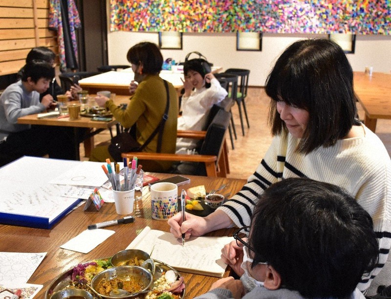 筆談をしながら食事を楽しむ人たち