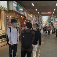 若者に声をかけ、居酒屋を尋ねる男2人組（右側）。この日は確認できただけで約7時間、50人に声をかけた＝JR高円寺駅周辺で2021年5月、小鍜冶孝志撮影（画像の一部を加工しています）