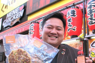 糖質オフのお好み焼きとソースを手にするくれおーる社長の加西幸裕さん＝大阪市中央区道頓堀1で2022年1月24日午後2時59分、長崎薫撮影