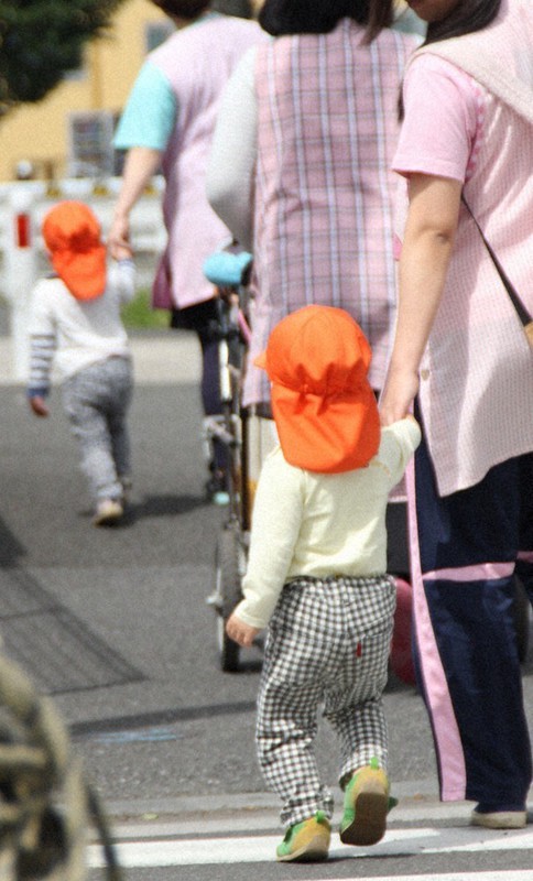 保育士と手をつないで散歩する子どもたち(本文とは関係ありません)