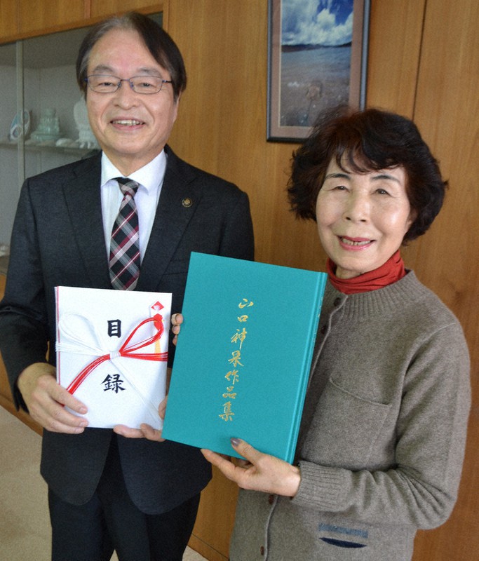 伊万里署市役所で深浦市長(左)に現金同封の寄付目録と作品集を手渡した山口さん