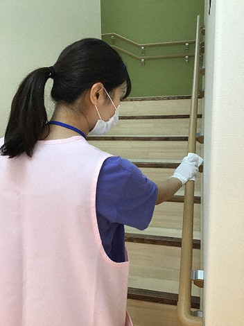 保育園の手すりを消毒する職員(記事中の認可保育所とは異なります)=保育園運営会社「さくらさくみらい」提供