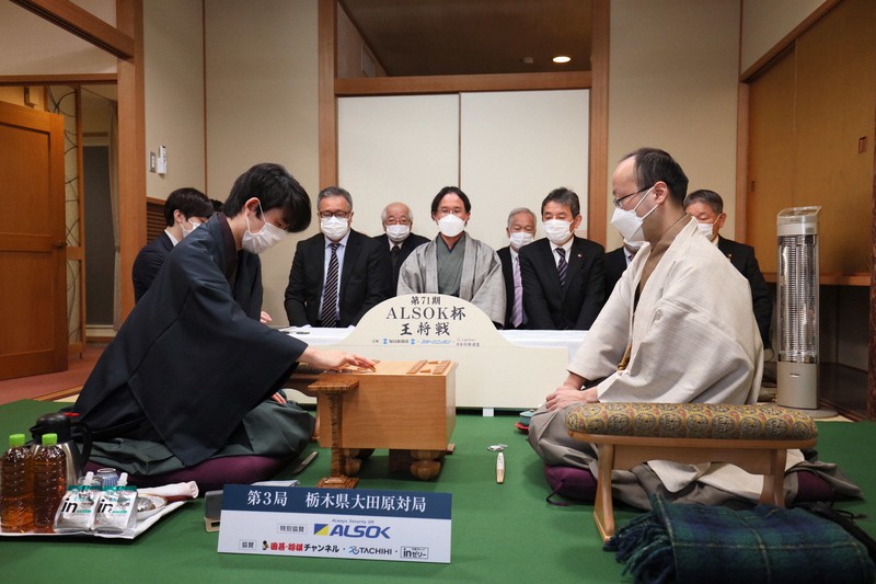 第71期ALSOK杯王将戦七番勝負第3局で初手を指す挑戦者の藤井聡太竜王(左)。右は渡辺明王将=栃木県大田原市のホテル花月で2022年1月29日午前9時、尾籠章裕撮影
