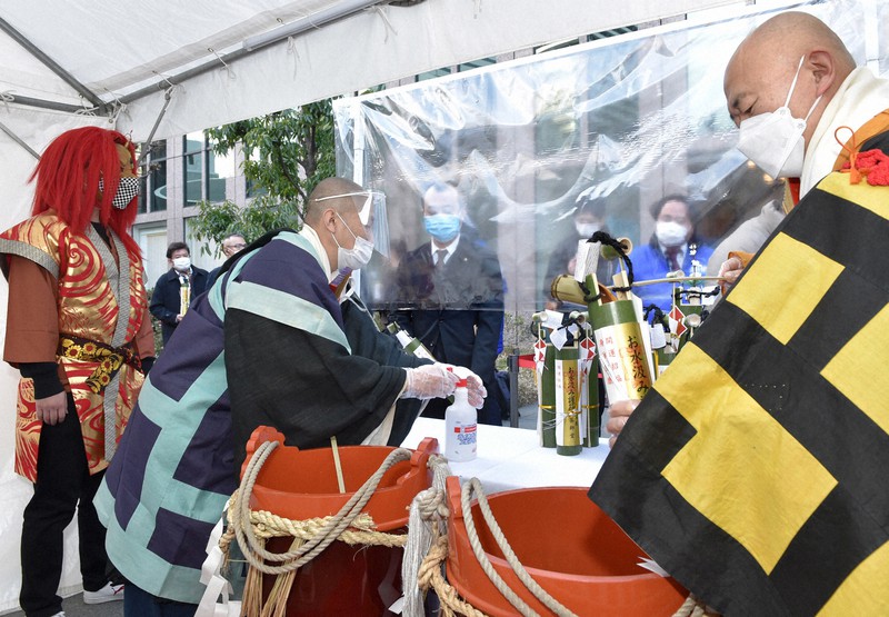 「堂島薬師堂節分お水汲み祭り」で参列者に「お香水」を渡す僧侶=大阪市北区で2022年2月3日午後3時32分、菱田諭士撮影