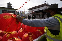 A worker exchanges hundreds of color-faded Red Chinese lanterns with new ones ahead of the Lunar New Year celebrations in the Chinatown district of Los Angeles, on Jan. 28, 2022. (AP Photo/Damian Dovarganes)