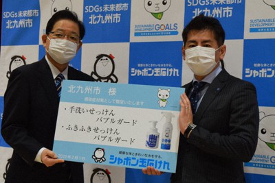 北橋健治市長（左）に無添加せっけんのハンドソープとスプレーの目録を手渡す森田社長