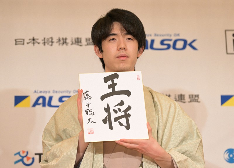最年少5冠を達成し「王将」と自筆した色紙を手にする藤井聡太新王将＝東京都立川市で2022年2月12日午後8時14分、大西岳彦撮影