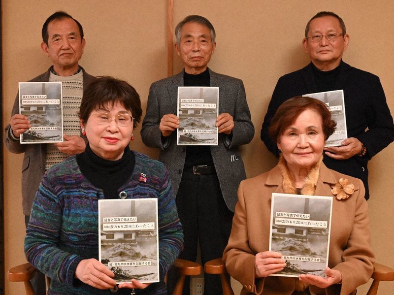 完成した記録集を手にする「北九州大水害を記録する会」共同代表の森下さん(前列左)、末永さん(後列左)、会員の吉永さん(前列右)ら