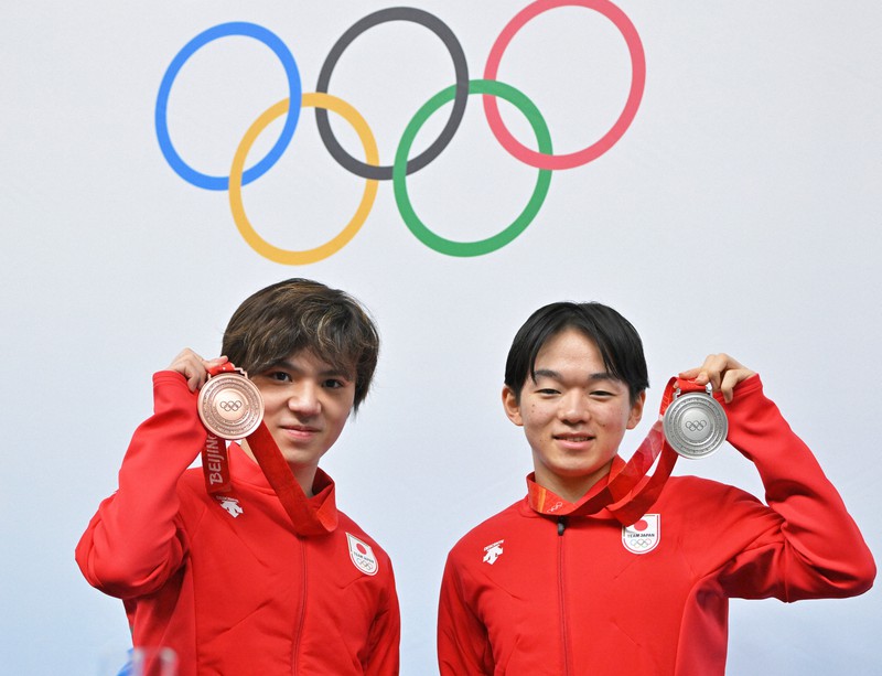 男子フリーから一夜明け、記者会見でメダルを見せる銀の鍵山優真(右)と銅の宇野昌磨=北京のメインメディアセンターで2022年2月11日午前9時24分、手塚耕一郎撮影