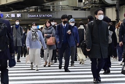 まん延防止等重点措置が適用され、マスク姿で交差点を歩く人たち＝大阪市北区で2022年1月27日午前8時半、藤井達也撮影