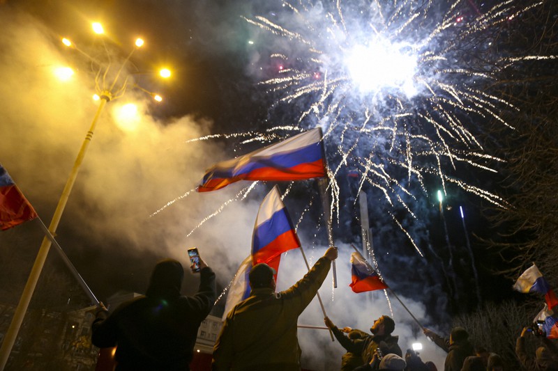 ロシア国旗を振って「独立承認」を祝う親露派地域の住民たち=ウクライナ東部ドネツクで2022年2月21日、AP